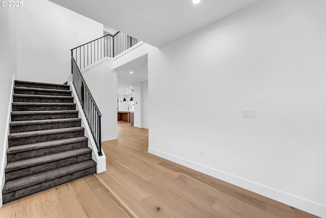 stairs with recessed lighting, baseboards, and wood finished floors