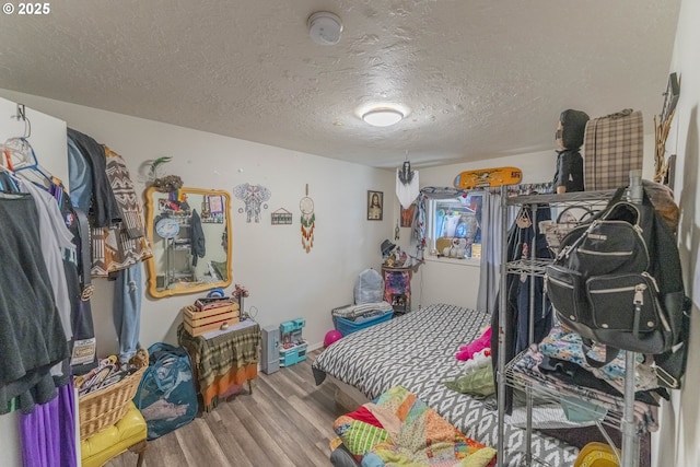 bedroom with a textured ceiling and wood finished floors