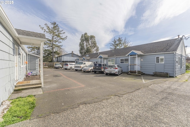 uncovered parking lot featuring entry steps and a residential view