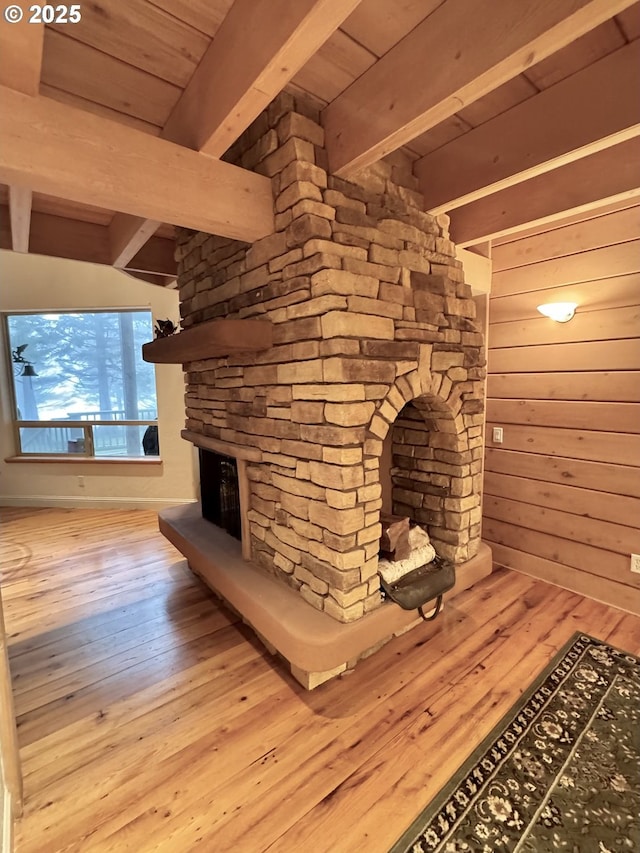31640 Spruce Dr, Gold Beach, OR 97444 - interior space with wood-type flooring, a stone fireplace, wood walls, and beam ceiling