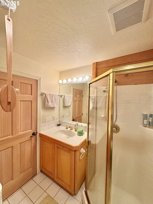 31640 Spruce Dr, Gold Beach, OR 97444 - full bathroom featuring vanity, a shower stall, a textured ceiling, tile patterned floors, and visible vents