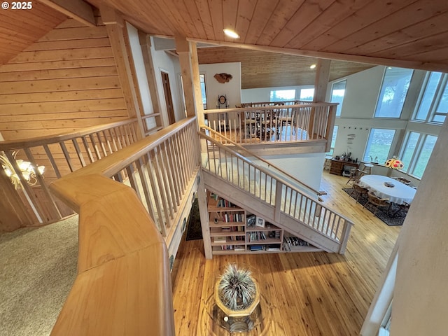 31640 Spruce Dr, Gold Beach, OR 97444 - stairway featuring high vaulted ceiling, wooden ceiling, wood walls, and hardwood / wood-style floors