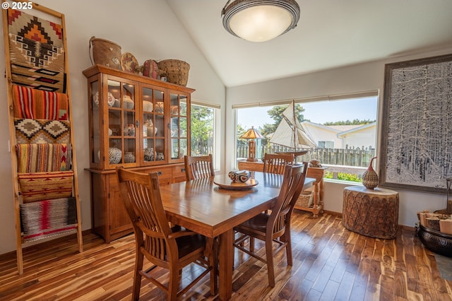 dining area featuring wood-type flooring, high vaulted ceiling, and a wealth of natural light