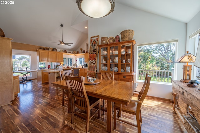dining area featuring baseboards, high vaulted ceiling, dark wood finished floors, and ceiling fan