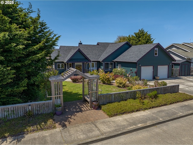 view of front facade with an attached garage, roof with shingles, fence, and driveway