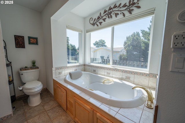 full bath featuring tile patterned floors, toilet, and a bath