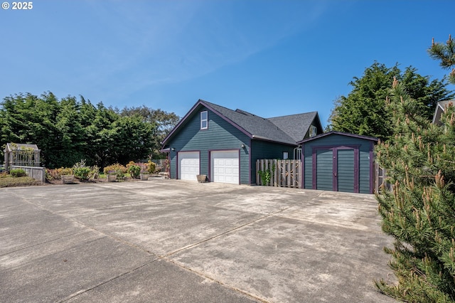 view of front of house featuring fence, an outdoor structure, and a storage unit