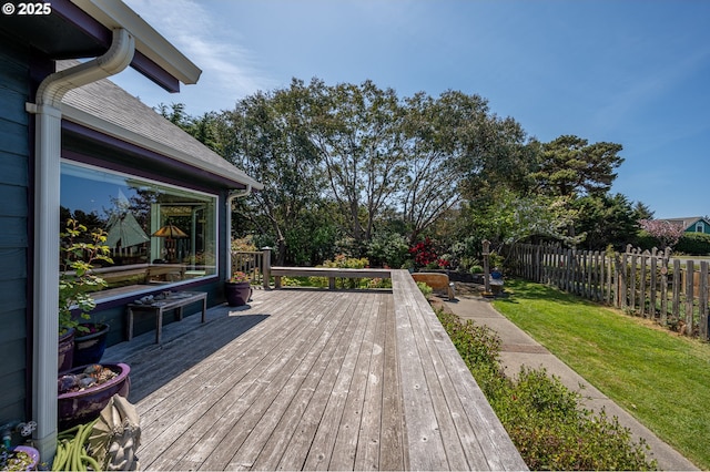 deck with a lawn and fence