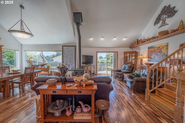 living room featuring high vaulted ceiling, hardwood / wood-style flooring, and stairs