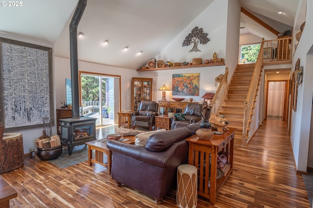 living area with a wood stove, hardwood / wood-style floors, high vaulted ceiling, stairway, and recessed lighting