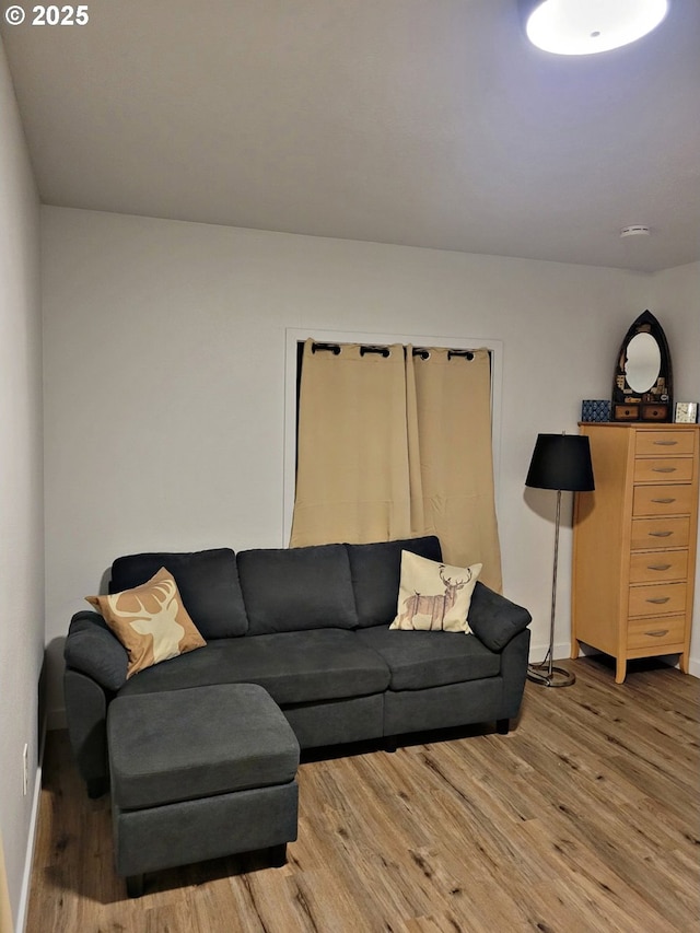 living area with baseboards and wood finished floors