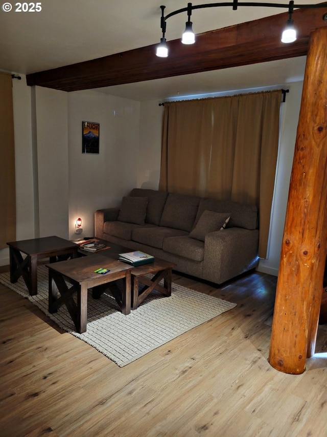 living room featuring beamed ceiling and light wood-type flooring