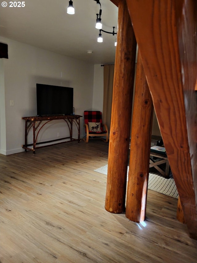 interior space featuring light wood-style floors, rail lighting, and baseboards