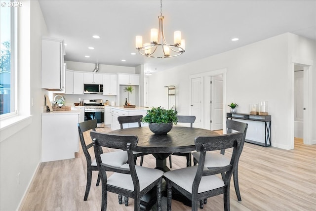 dining area featuring light wood-type flooring and a chandelier