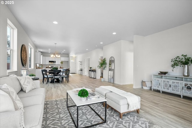 living room with an inviting chandelier and light hardwood / wood-style floors