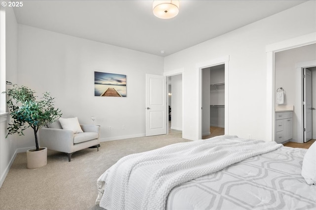 carpeted bedroom with ensuite bathroom, a closet, and a spacious closet