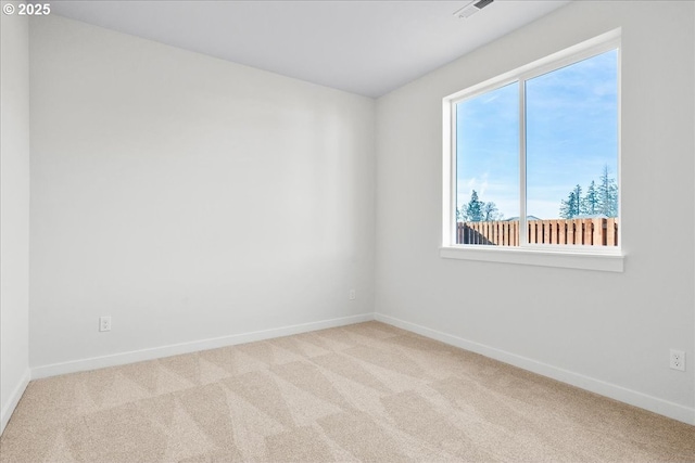 unfurnished room featuring a wealth of natural light and light colored carpet