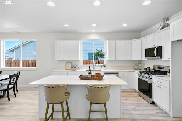 kitchen with white cabinetry, a center island, and stainless steel appliances