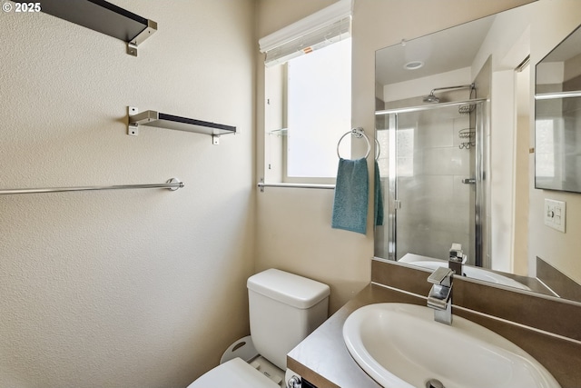 bathroom with a stall shower, toilet, and vanity