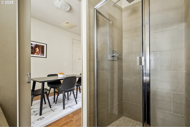 bathroom featuring visible vents, wood finished floors, and a stall shower