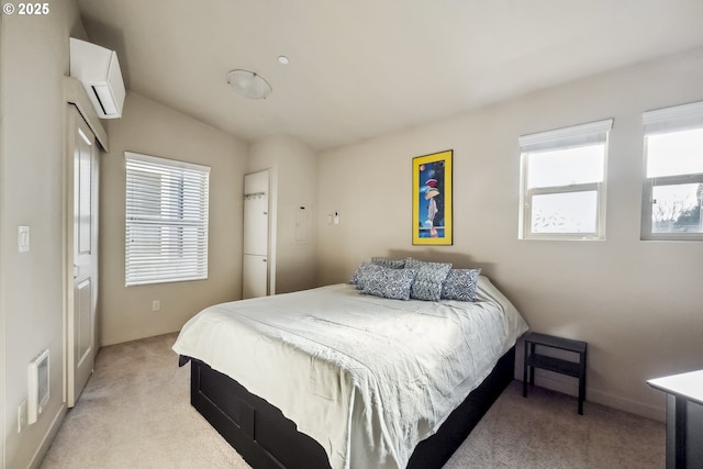 bedroom featuring multiple windows, light colored carpet, and a wall unit AC