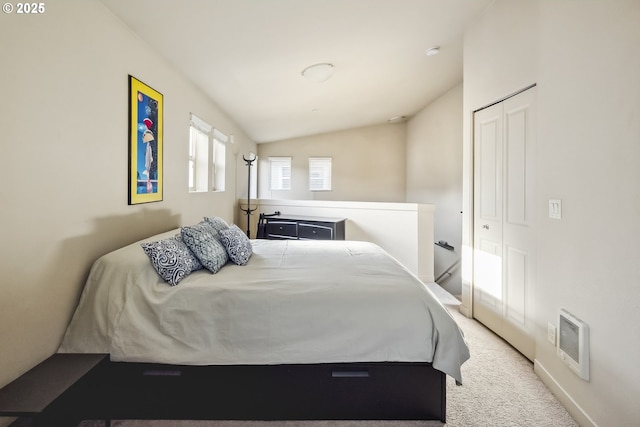 carpeted bedroom with a closet, visible vents, and lofted ceiling