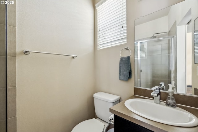 full bathroom featuring a shower stall, toilet, and vanity