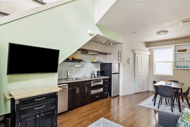 kitchen with visible vents, a sink, appliances with stainless steel finishes, light wood-style floors, and open shelves