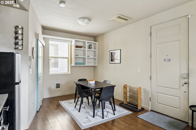 dining space with visible vents, baseboards, and wood finished floors