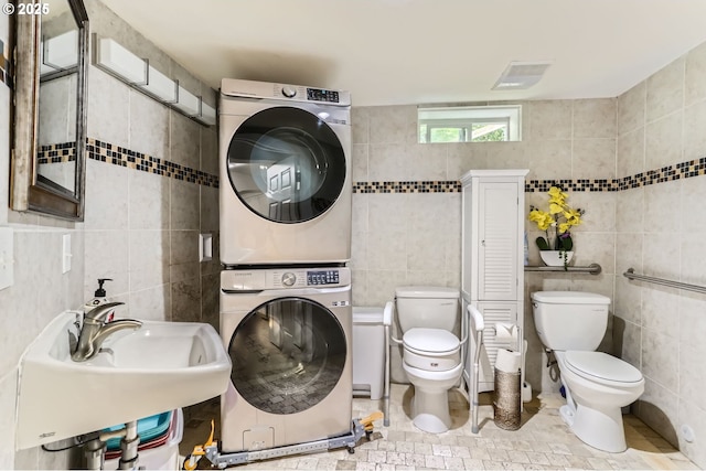 16500 SW Satterberg Rd, Beaverton, OR 97007 - bathroom with stacked washer and clothes dryer, tile walls, toilet, and a sink