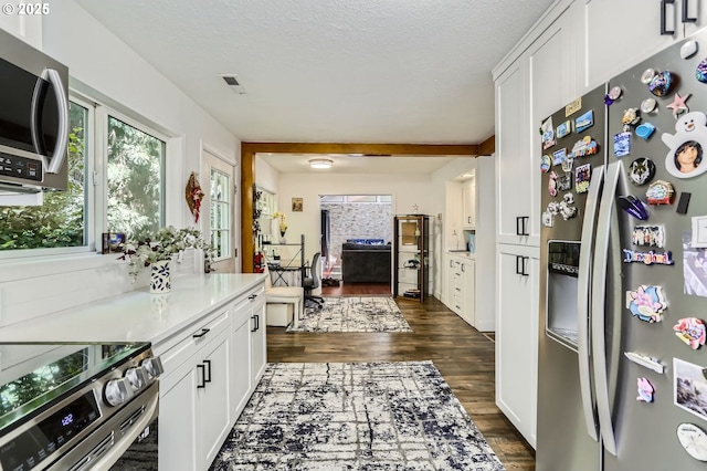 16500 SW Satterberg Rd, Beaverton, OR 97007 - kitchen with stainless steel appliances, dark wood-style floors, white cabinetry, light countertops, and a textured ceiling