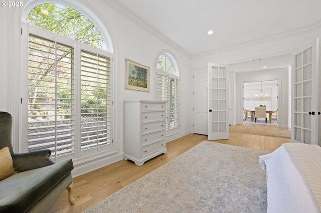 bedroom with baseboards, french doors, wood finished floors, and ornamental molding