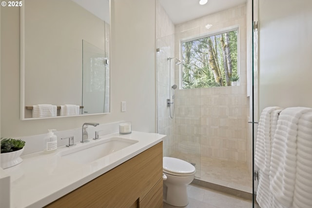 full bathroom with toilet, vanity, tile patterned floors, and a tile shower
