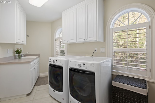 laundry room with cabinet space, independent washer and dryer, light tile patterned floors, and a sink