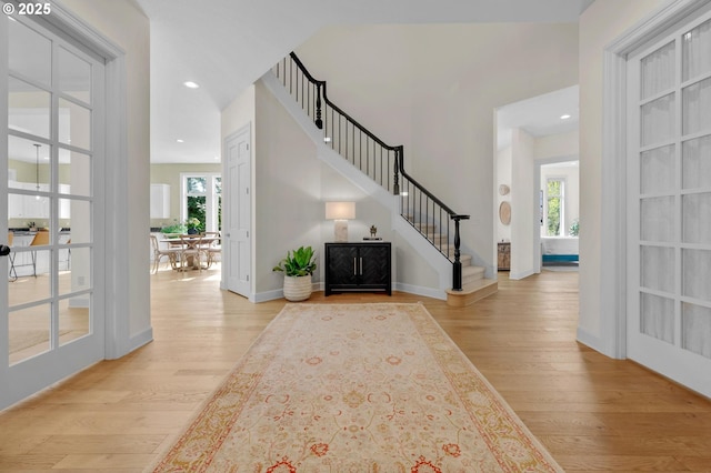 foyer with baseboards, wood finished floors, recessed lighting, and stairway
