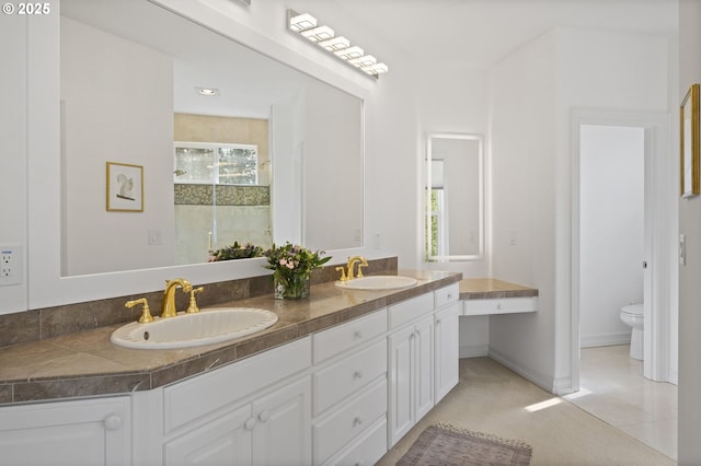 full bathroom with double vanity, a wealth of natural light, toilet, and a sink
