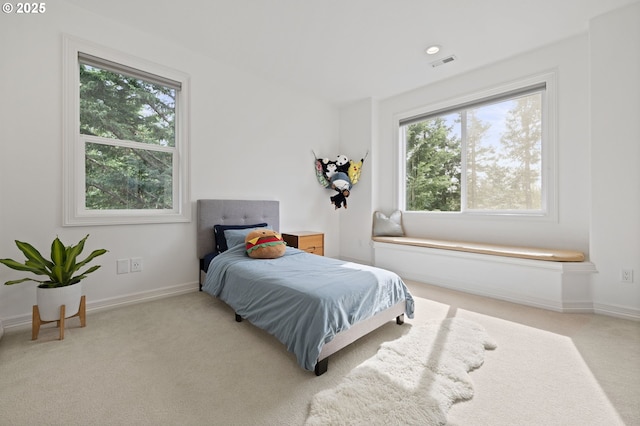 carpeted bedroom featuring baseboards and visible vents