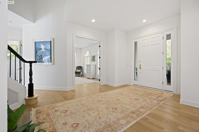 entrance foyer with recessed lighting, stairway, light wood finished floors, and baseboards