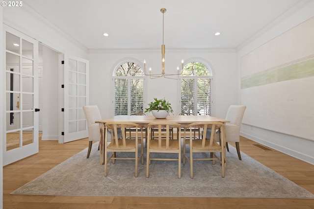 dining room with ornamental molding, a notable chandelier, french doors, and visible vents