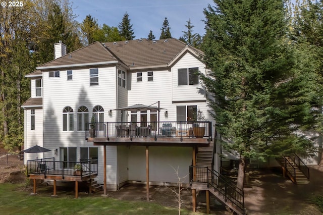 rear view of property featuring stairway, a chimney, and a deck