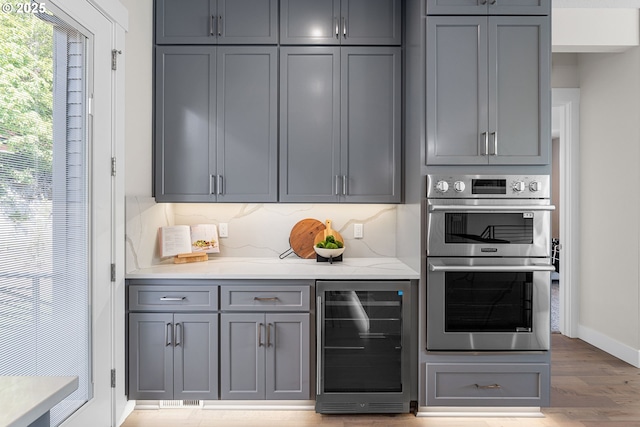 565 W U St, Washougal, WA 98671 - interior space with tasteful backsplash, baseboards, double oven, light wood finished floors, and beverage cooler