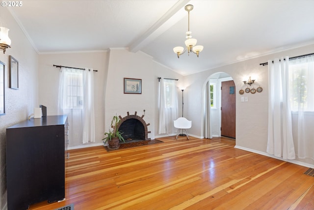 6815 N Smith St, Portland, OR 97203 - unfurnished living room featuring arched walkways, light wood-style floors, a chandelier, a brick fireplace, and baseboards
