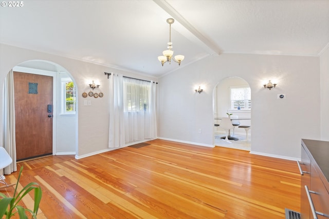6815 N Smith St, Portland, OR 97203 - unfurnished living room with arched walkways, light wood-style flooring, a chandelier, and baseboards