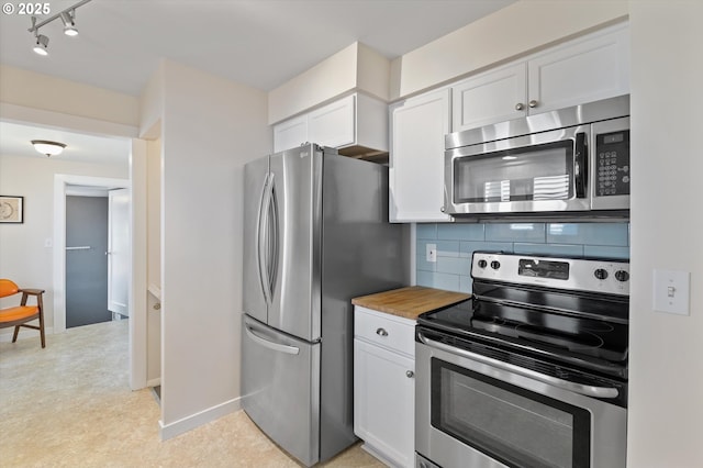 6815 N Smith St, Portland, OR 97203 - kitchen featuring appliances with stainless steel finishes, white cabinetry, backsplash, light floors, and baseboards