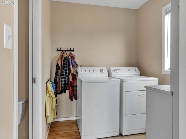 laundry area featuring laundry area, light wood finished floors, and washing machine and dryer