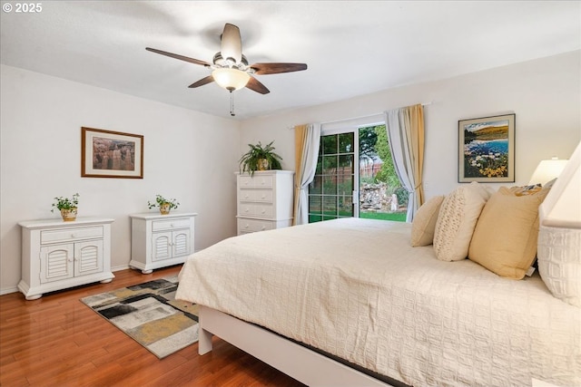 bedroom featuring a ceiling fan, baseboards, and wood finished floors