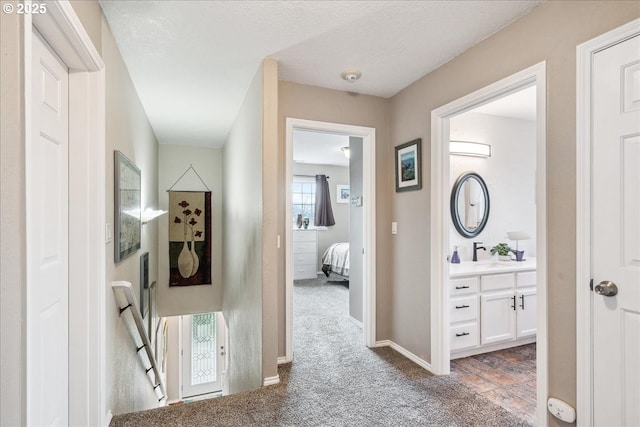 hallway featuring carpet floors and baseboards