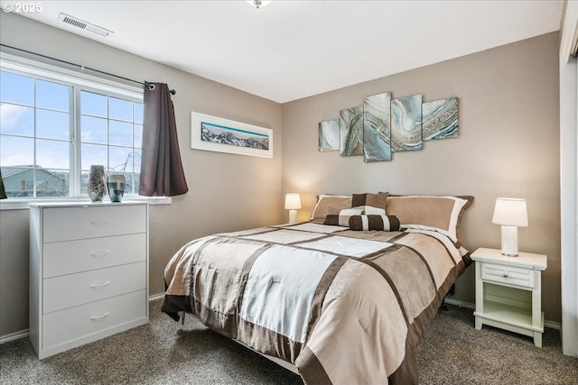 bedroom with dark carpet, visible vents, and baseboards