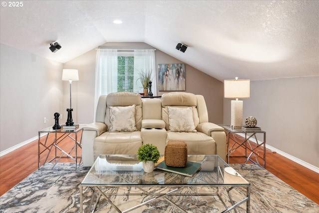 sitting room with a textured ceiling, vaulted ceiling, and wood finished floors