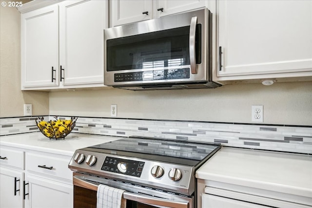 kitchen with stainless steel appliances, light countertops, and white cabinetry